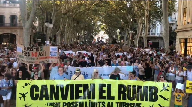 They don't want tourists in the country! 10,000 people took to the streets with giant banners