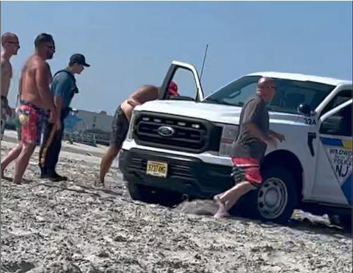 Woman sunbathing trapped under police car in a horrific accident on the beach