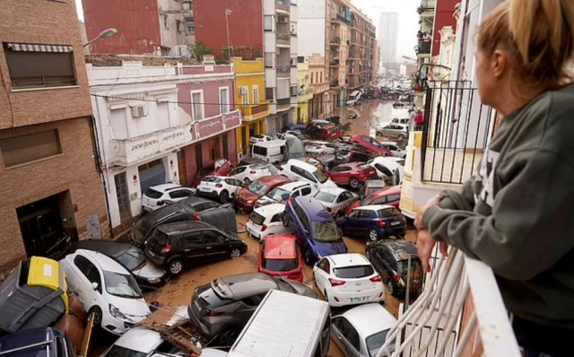 A woman and her dog swept away by floodwaters in Spain were rescued at the last moment