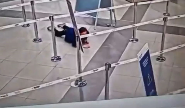 A ticketless female passenger crawled under the security barrier and boarded the plane