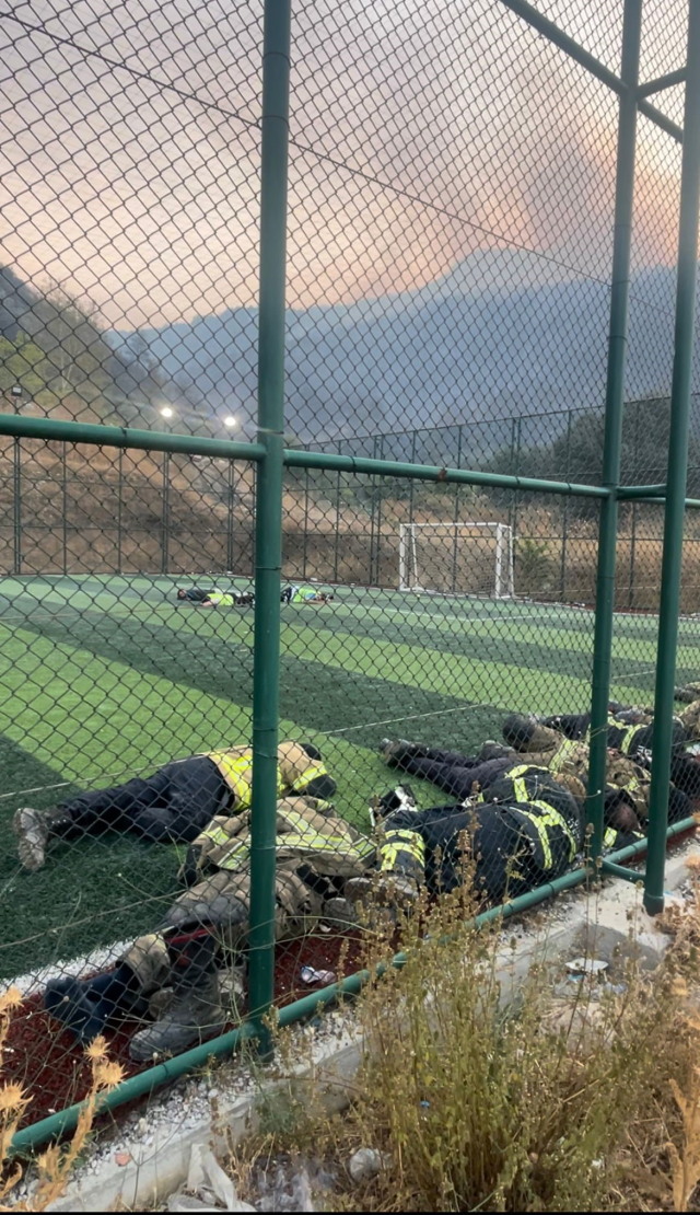Firefighters who fought the flames for 12 hours rested like this on the field