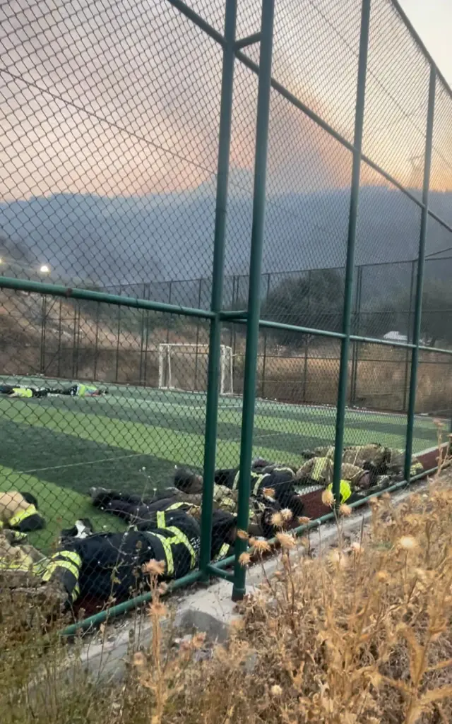 Firefighters who fought the flames for 12 hours rested like this on the field