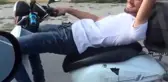 Koltuğuna Sırt Üstü Yattığı Motosikleti Tek Elle Kullanıyor