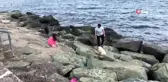Kayalıklara sıkışan köpeği sahilden geçen bir genç kurtardı
