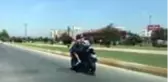 Motosikletlinin çantasındaki güneş gözlüklü köpek ilgi odağı oldu