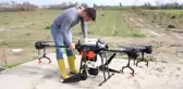 Antalya'da bir üretici üzerinde 10 litrelik depo bulunan droneyi zirai ilaçlamada kullanıyor