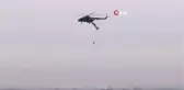 Askeri helikoptere takılan paraşütçü havada asılı kaldı