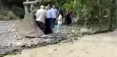 Çayın karşısına geçmeye isteyen vatandaşları kepçe taşıdı