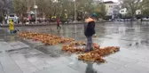 Temizlik işçisi ağaçlardan düşen yapraklarla 