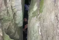 The woman trying to pick up her fallen phone got stuck upside down between the rocks.