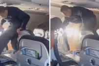 A passenger who was trying to break the airplane seat by kicking it was subdued by other passengers.