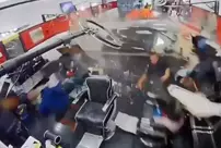 The out-of-control luxury car crashed into the barber shop.