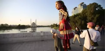 Little Amal walked along while refugee children sang songs