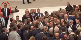 He watched the fight that broke out in the parliament, leaning on the podium and smiling.