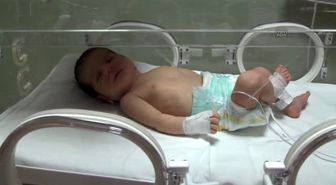 Mezarlık Kapısı Önünde Bulunan Bebek