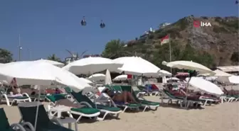 Alanya'da aşırı sıcaktan bunalan tatilciler sahile akın etti