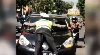 Trafik polisi, kırmızı ışıkta geçen otomobilin kaputuna çıktı