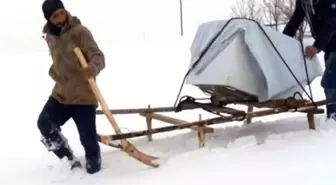 Kar yağışının esir aldığı kentte, arızalı bulaşık makinesi kızakla taşındı