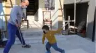 Evin kapısında oğluyla tahtadan kılıç yapıp, oynadı