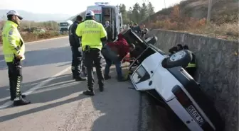 SU KANALINA DEVRİLEN OTOMOBİLDE SIKIŞAN SÜRÜCÜYÜ İTFAİYECİLER KURTARDI