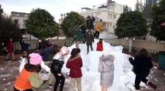 Kamyonla okul bahçesine taşınan kar öğrencilerin neşe kaynağı oldu