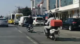 Tehlikeli yolculuk: Akan trafikte motosikleti halatla çekti