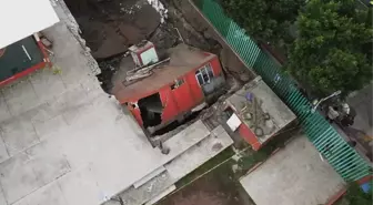 Meksika'da bir bina yolda oluşan dev çukurun içine devrildi