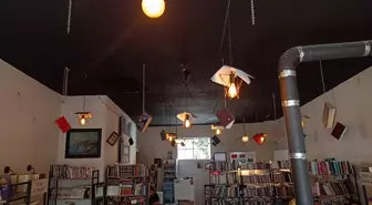 Kitapları, dijital çağa yenilmesine dikkat çekmek için kafenin tavanına astı
