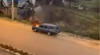 Motorundan tutuşan otomobili kovayla taşıdığı suyla söndürdü