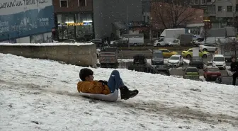 Erzurum'da kar yağışını fırsat bilen çocuklar mahalle aralarında poşet ve kızakla kaydı