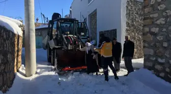 Kardan yolu kapanan mahallede hastalanan kadın, kepçeyle ambulansa taşındı