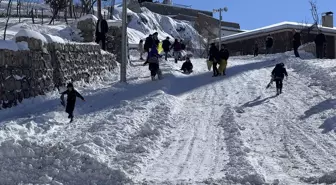 Şırnak'ta çocuklar kar keyfini poşet ve tepsilerle kayarak çıkardı
