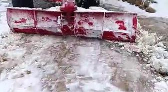 Batman'da muhtar, yolun kapanmaması için traktörle kar birikintilerini temizledi