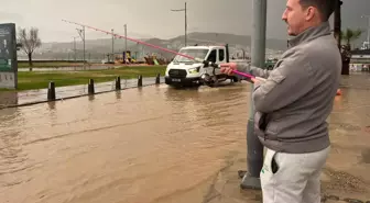 İzmir'de sağanak hayatı felç etti, oltasını kapan yola attı