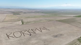 Çiftçi traktörüyle tarlasına 'Korkma' yazdı