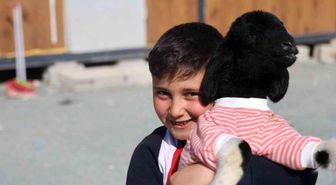 Annesi doğumda telef olan 'Boncuk' kuzu, elbisesi ve biberonuyla ilgi odağı oldu