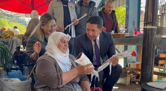 Feke Belediye Başkanı Cömert Özen, pazarda kadınlarla çiçek verdi
