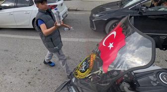 Su satan çocuk, camında Türk bayrağı olan motosikletliye su hediye etmek istedi