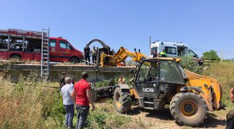 Köprüden düşen traktörün altında kalan sürücü iş makinesiyle kurtarıldı