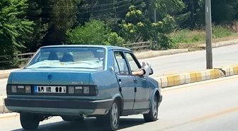 Ayaklarını camdan dışarı çıkartan yolcu trafiği riske attı