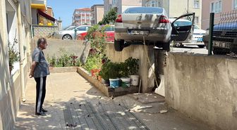 El freni çekilmeyen otomobil, hareket edip istinat duvarında asılı kaldı