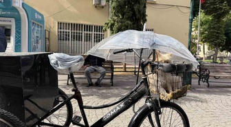 Eskişehir'de sağanakta üç tekerlekli bisikletli, sepetindeki köpeği şemsiyeyle korudu