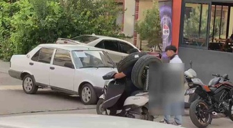 Ankara'da görenleri şaşkına çeviren kurye! Otomobil lastiğini boynuna asıp motosiklet kullandı