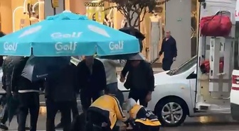 Bursa Osmangazi'de otomobilin çarptığı yaya, yağmurda şemsiyelerle korundu