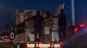 Diyarbakır'da iki kişi eşya düşmesin diye kamyonet kasasına tutunup ilerledi
