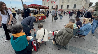 Turist kadınlar Eminönü Meydanı'nda tarihi yapıları ve günlük yaşamı tuvale taşıdı