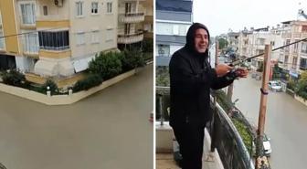 Sokaklar göle döndü ama o balkondan olta attı