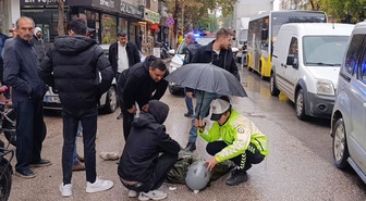 İnegöl'de yağmurda yerde yatan yaralıya kadın polis şemsiye tuttu! Ambulans gelene kadar başından ayrılmadı
