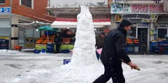 Hem dükkanlarının önünü temizlediler hem de kardan adam yaptılar