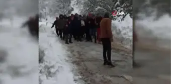 Kardan kapanan yolu açmaya çalışan iş makinesi devrildi: 2 yaralı